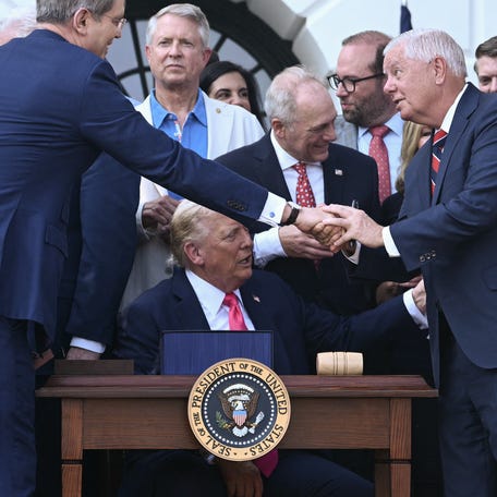 US Treasury Secretary Scott Bessent (L) shakes hands with Senator Lindsey Graham, Republican of South Carolina, after President Donald Trump (C) signed the "Big Beautiful Bill Act" at the White House in Washington, DC, on July 4, 2025.
