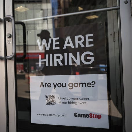A sign for hire is posted on the door of a GameStop in New York City, U.S. REUTERS/Shannon Stapleton