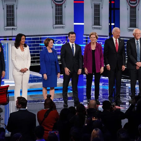 Democratic U.S. presidential candidates Senator Cory Booker, Rep. Tulsi Gabbard, Senator Amy Klobuchar, South Bend Mayor Pete Buttigieg, Senator Elizabeth Warren, former Vice President Joe Biden, Senator Bernie Sanders and Senator Kamala Harris pose at the start of their fifth 2020 campaign debate at the Tyler Perry Studios in Atlanta, Georgia, on November 20, 2019.