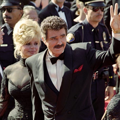 Burt Reynolds waves to the crowd upon his arrival with his wife Loni Anderson at the 44th Annual Emmy Awards in Pasadena on Aug. 30, 1992.