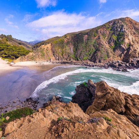 Breathtaking view of Pfeiffer Beach in Big Sur, California, featuring its iconic rock arch, golden sand, and turquoise waves. A stunning coastal landscape perfect for travel and nature lovers