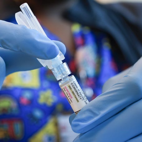 In this photo illustration, Ruth Jones, Immunization Nurse, holds a Pfizer-BioNTech COVID-19 vaccine at Borinquen Health Care Center on May 29, 2025 in Miami, Florida.