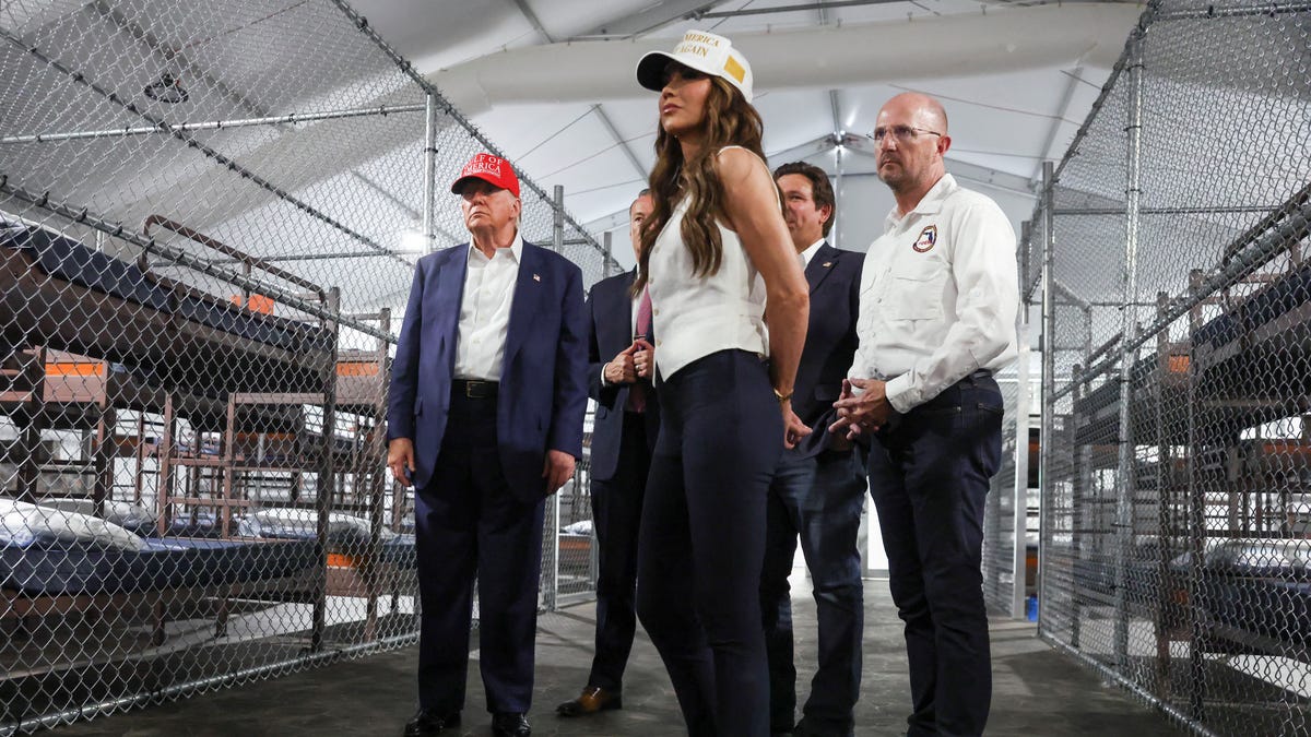 President Donald Trump, Florida Gov. Ron DeSantis, and U.S. Homeland Security Secretary Kristi Noem are pictured visiting a temporary migrant detention center in Ochopee, Florida, dubbed "Alligator Alcatraz."