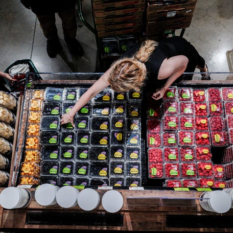 People shop for groceries at a store in New York City.