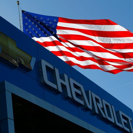 The Chevrolet logo and the U.S. flag are seen at an auto dealership in Gaithersburg, Maryland, U.S.