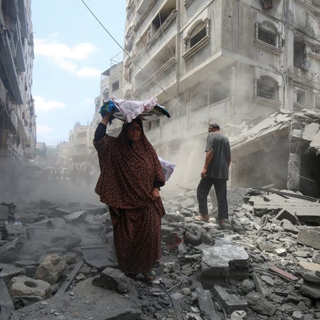 Palestinians inspect the site of a morning Israeli strike on a house in Gaza City on Aug. 8, 2025.