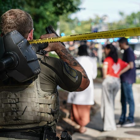 A law enforcement officer walks under police line tape near the Centers For Disease Control (CDC) Global Headquarters during an active shooter incident on Aug. 8, 2025 in Atlanta, Georgia. According to the Atlanta Police Department, the suspect in the active shooter situation is dead and a police officer was injured.