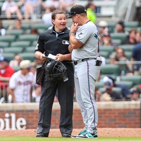 MLB umpire Jen Pawol (95) speaks with Miami Marlins manager Clayton McCullough (86) during eighth inning against the Atlanta Braves at Truist Park in Cumberland, Georgia on Aug. 10, 2025.