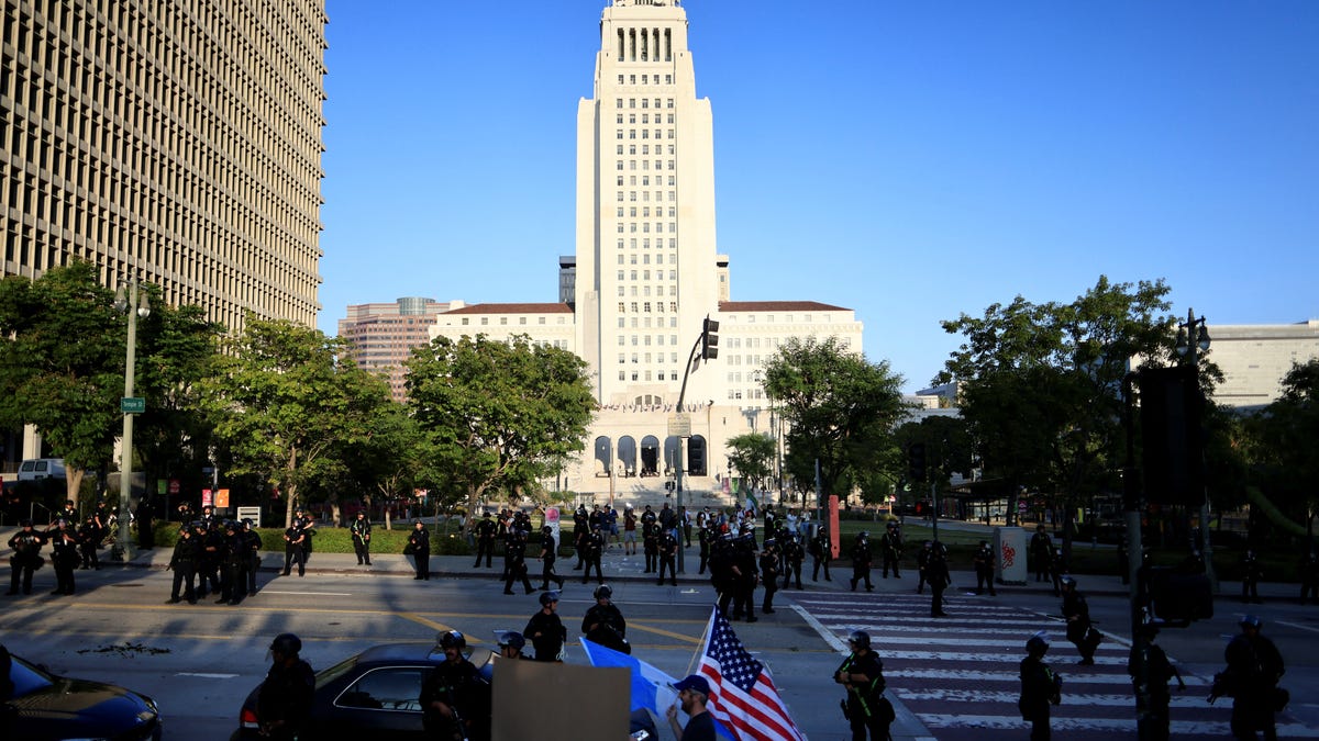 Law enforcement officers stand guard as people protest against federal immigration sweeps, outside the city hall in downtown Los Angeles, California, U.S., June 11, 2025. REUTERS/David Swanson