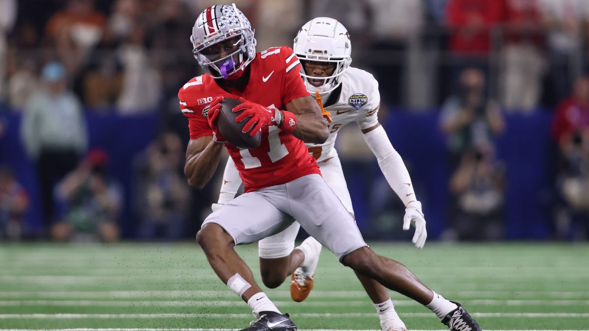 Ohio State wide receiver Carnell Tate (17) makes a catch against Texas defensive back Malik Muhammad (5) during the College Football Playoff semifinal in the Cotton Bowl at AT&T Stadium.