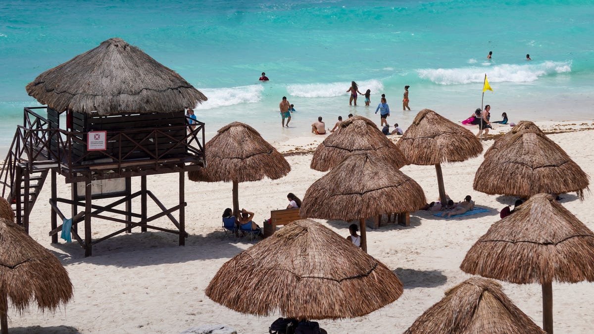 Tourists are pictured on the beach in the city of Cancun, Quintana Roo State, Mexico on July 2, 2024