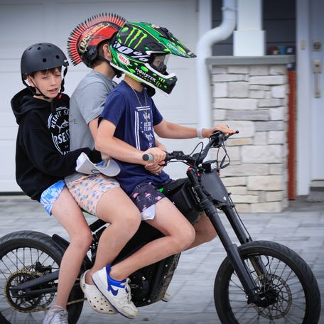 Kids ride an e-bike on May 25, 2025, in Point Pleasant, New Jersey.