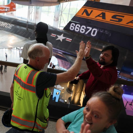 Museum employees high-five as they watch visitors enter the Smithsonian National Air and Space Museum's reconstructed north entrance and Boeing Milestones of Flight Hall for the first time, on the National Mall in Washington, U.S. July 28, 2025. The museum, which is one of the world's most visited, is scheduled to fully reopen for its 50th anniversary in 2026.