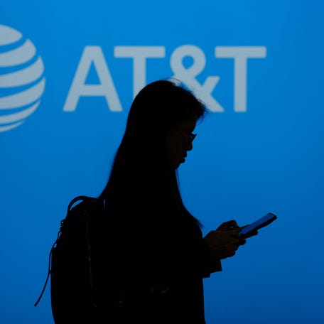 A visitor walks past US multinational telecommunications AT&T logo during the Mobile World Congress (MWC), the telecom industry's biggest annual gathering, in Barcelona on February 26, 2024.