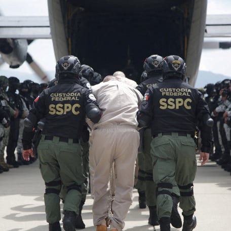 Members of Mexico's federal forces escort prisoners wanted in the U.S. for ties to drug-trafficking groups into a plane, amid rising pressure from President Donald Trump on Mexico to dismantle the country's drug organizations, at the Toluca International Airport, in San Pedro Totoltepec, Mexico, August 12, 2025.