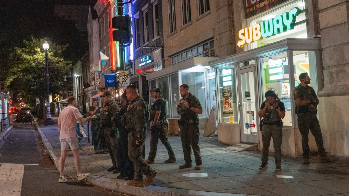 A man, who was later arrested, interacts with federal agents along the U Street corridor of Washington, D.C., on Aug. 10, 2025. President Donald Trump ordered an increased presence of federal law enforcement to the city in an effort to curb crime.