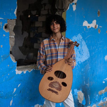 Palestinian Youssef Saad, 18, holds an oud as he poses for a portrait, at Gaza College where instructors from Edward Said National Conservatory of Music train Palestinians, in Gaza City, August 9, 2025.