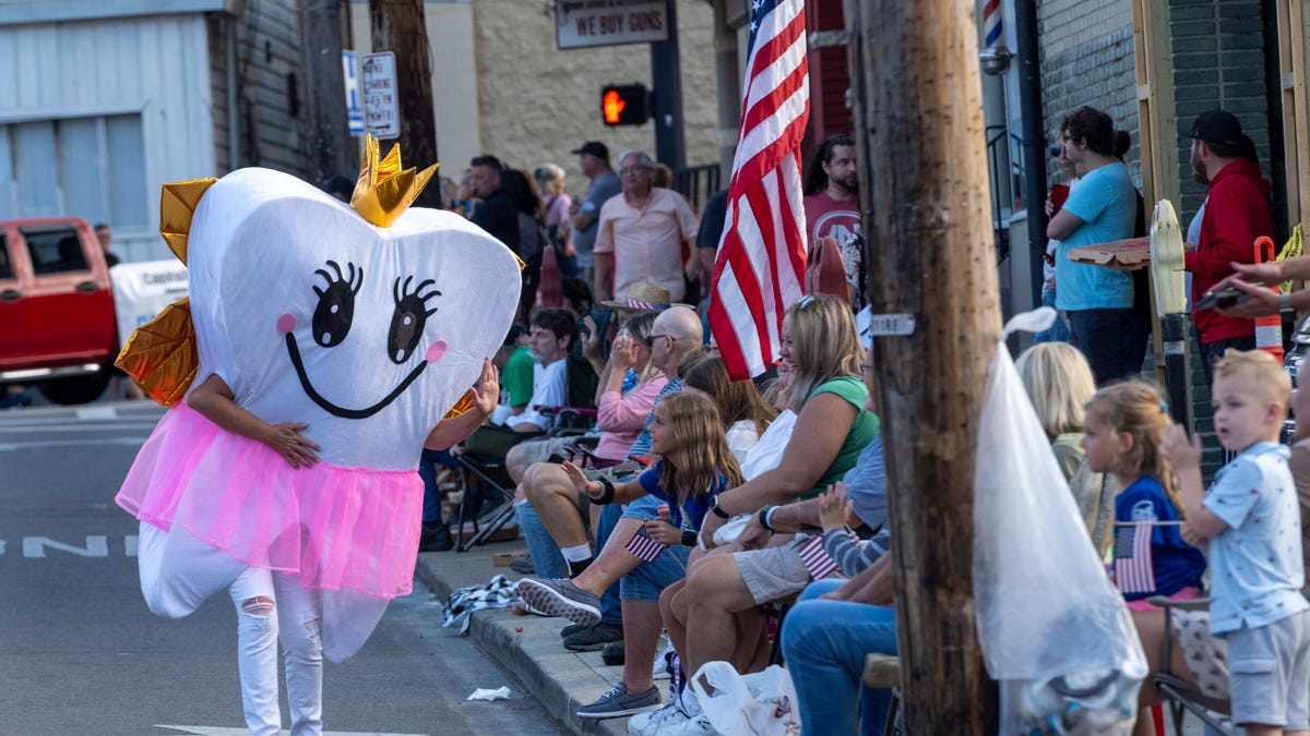 The Tooth Fairy waves to children at the 2023 Harvest Home Parade in Ohio.