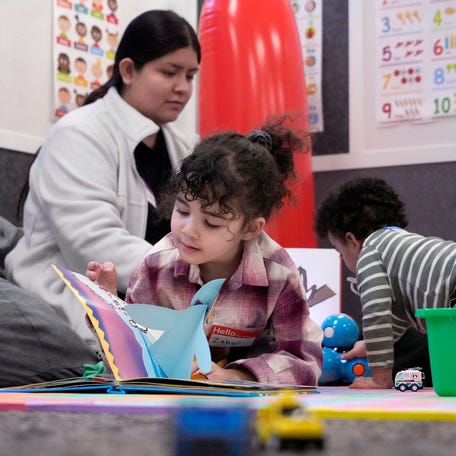 5-year-old Zahari Westfahl looks through a book as Briana Martinez, an education student, plays with 2-year-old Ziyad Salem at Milwaukee Area Technical Collegeâ€™s new drop-in child care center at its downtown campus in Milwaukee on Tuesday, March 4, 2025.