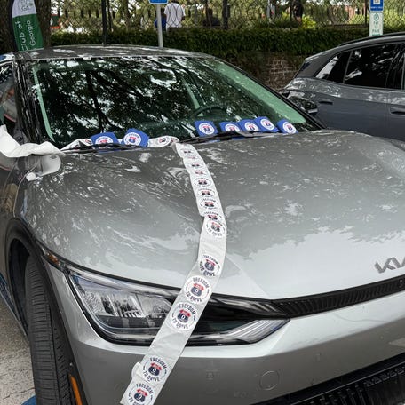 An electric Kia model with "Power to Drive" stickers strewn over it at the Aug. 7 press event, How EV Investments Are Powering Prosperity in Georgia