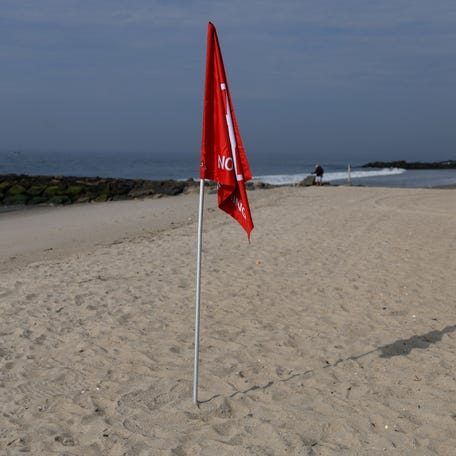 A red no swimming flag stands on a NYC beach where a swimmer was attacked by a shark near Queens on August 10, 2023.