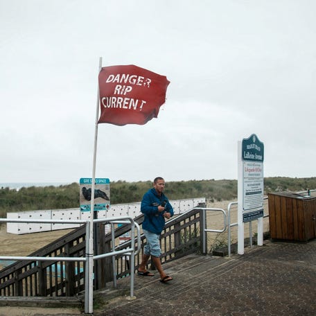 A person exits the beach during Hurricane Erin, the first hurricane of the 2025 Atlantic season, in Avon-by-the-Sea, New Jersey, on August 20, 2025.