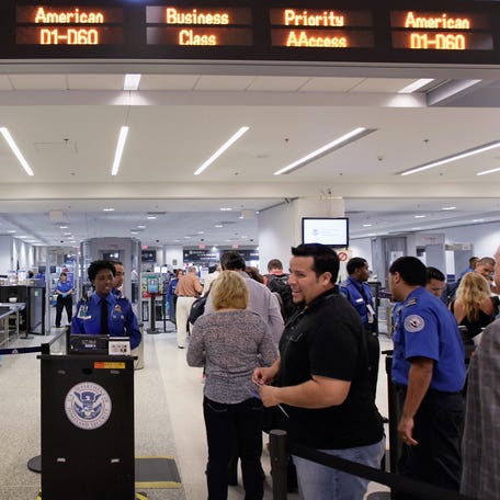 Passengers wait to clear security next to the newly opened TSA PreCheck lane at Miami International Airport on October 4, 2011 in Miami, Florida.