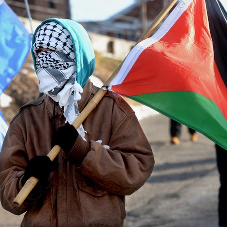 A protester who did not want to giver her name carries a Palestinian flag during the Jan. 20 We Fight Back protest in Springfield Monday, Jan. 20, 2025.