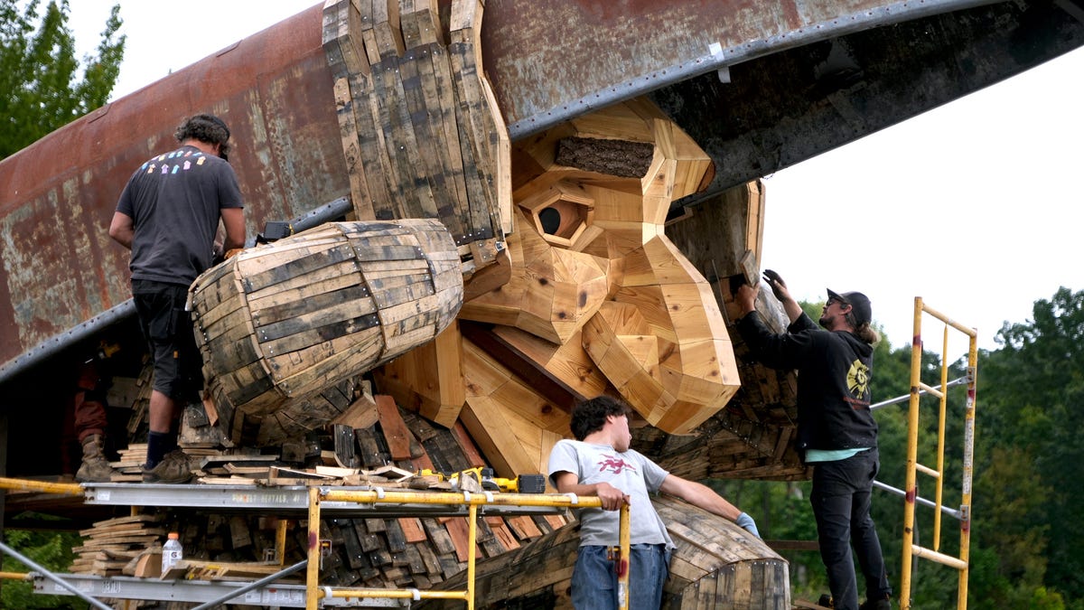 Sebastian Claudio, Donnie Azar and Scott Davis finish up work Aug. 21 under the watchful eye of Mrs. Skipper, the East Providence troll at Kettle Point. The Rhode Island Troll Trail was finished in August with troll locations in East Providence, North Kingstown and Arcadia.
