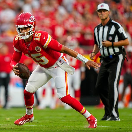 Aug 22, 2025; Kansas City, Missouri, USA; Kansas City Chiefs quarterback Patrick Mahomes (15) scrambles from Chicago Bears defensive end Dominique Robinson (90) during the first half at GEHA Field at Arrowhead Stadium.