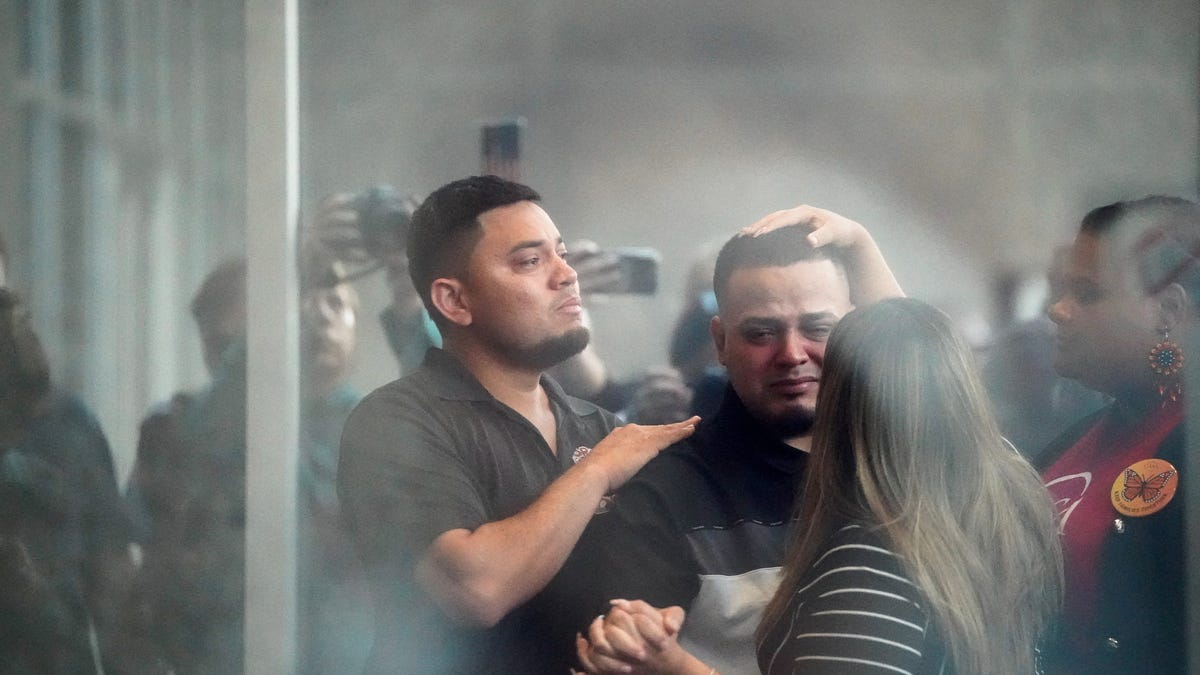 Kilmar Abrego Garcia holds his wife Jennifer Vasquez Sura's hand as he appears for a check-in at the ICE Baltimore field office in Maryland on August 25, 2025.