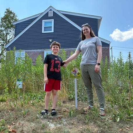 Aimee Kemp, right, and her son, Auron, have transformed their yard into a native plant garden. While it helps to restore native habitats, their yard has faced violations by their Long Island village government for being "unsightly."