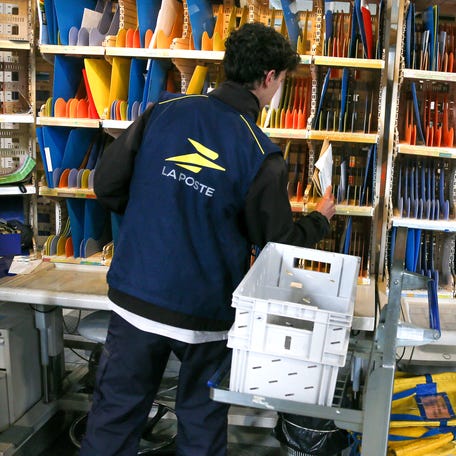 A La Poste employee sorts letters on shelves and racks according to addresses, in preparation for a mail delivery round by a letter carrier, at the postal sorting center in Valence, France, on April 30, 2024.