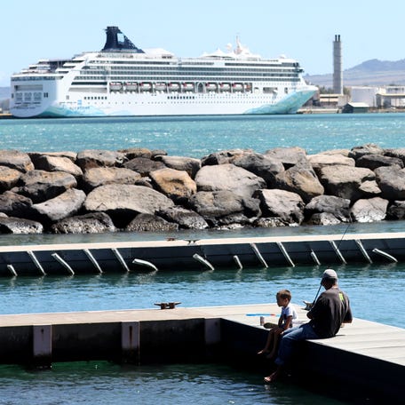 People fish near the Norwegian Spirit cruise ship, moored at Kahului Harbor in Maui during a tourism visit, on October 6, 2023.