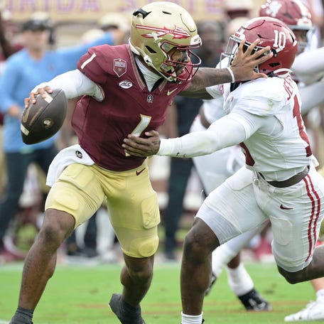 Florida State quarterback Tommy Castellanos (1) stiff arms Alabama linebacker Justin Jefferson (10) during the second half at Doak S. Campbell Stadium.
