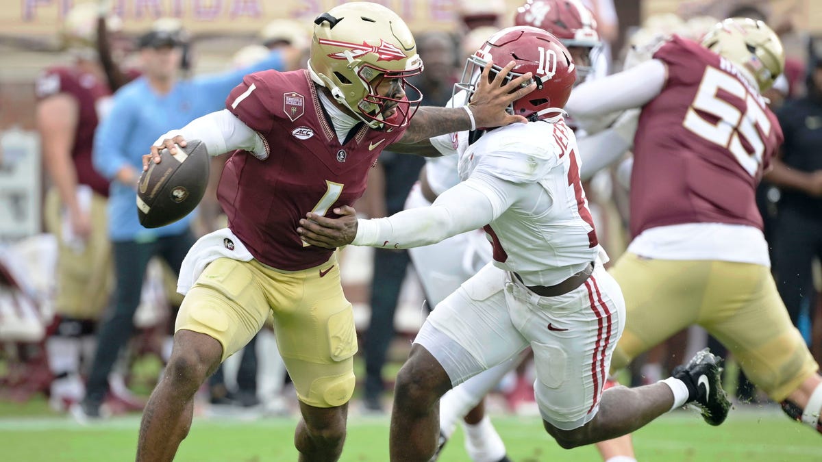 Florida State quarterback Tommy Castellanos (1) stiff arms Alabama linebacker Justin Jefferson (10) during the second half at Doak S. Campbell Stadium.