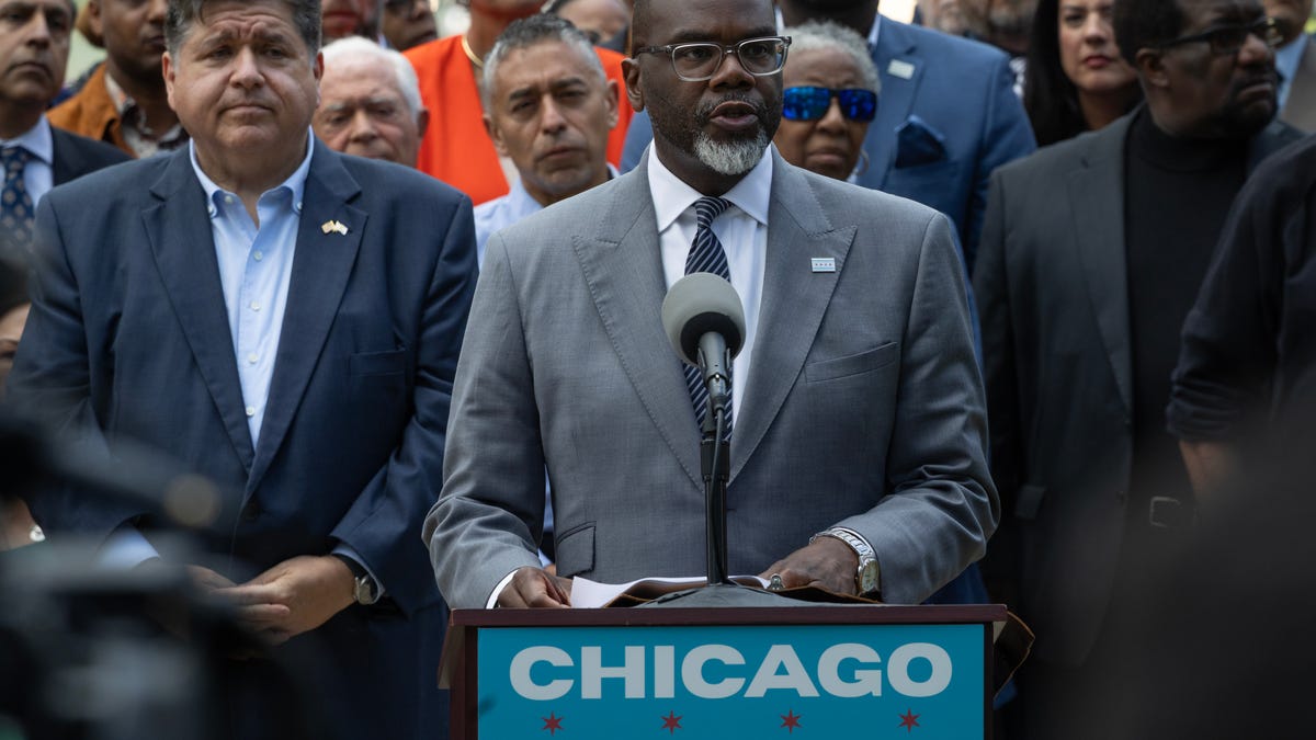 Flanked by Illinois Gov. JB Pritzker (L) and other Illinois politicians and community leaders, Chicago Mayor Brandon Johnson speaks at an Aug. 25, 2025, news conference to address President Donald Trump's plan to send National Guard troops into the city.