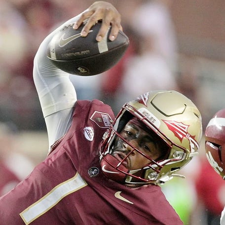 Florida State Seminoles quarterback Tommy Castellanos (1) loses his footing against Alabama Crimson Tide linebacker Jah-Marien Latham (20) during the second half at Doak S. Campbell Stadium.
