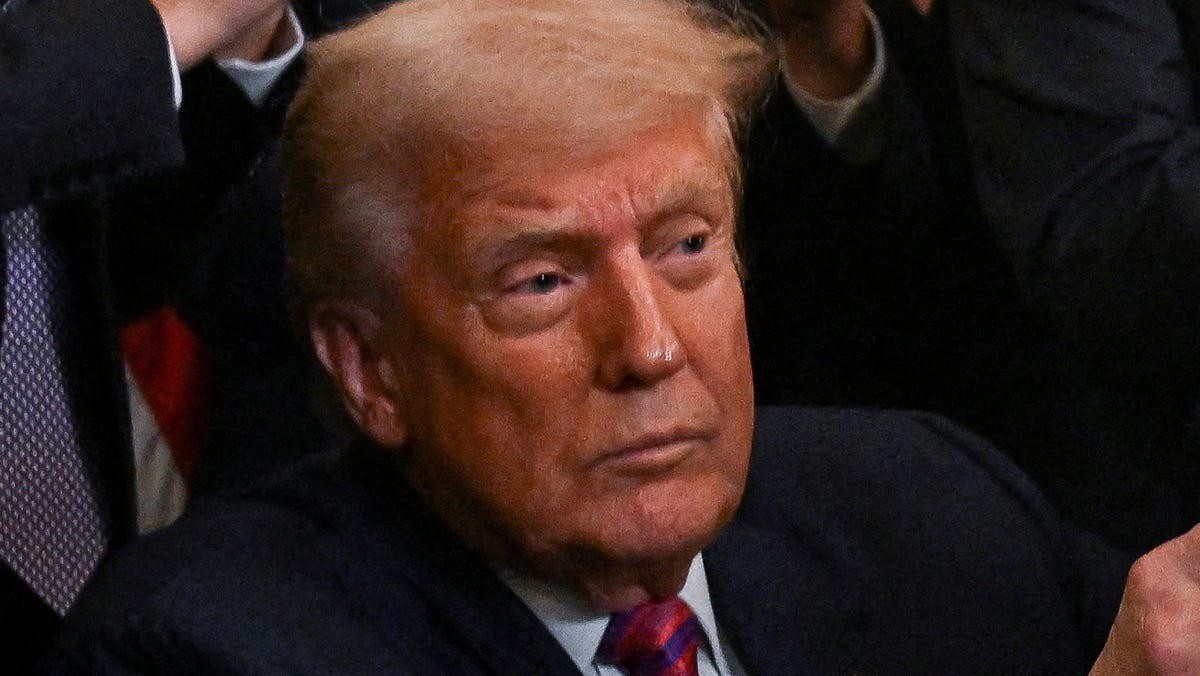 President Donald Trump holds the signed "Genius Act," which will develop a regulatory framework for stablecoin cryptocurrencies and expand oversight of the industry.