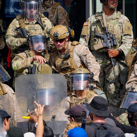 Marines and National Guard troops communicate as they deal with protesters on the front steps of the Edward Roybal Federal Building in Los Angeles, Calif., June 14, 2025.