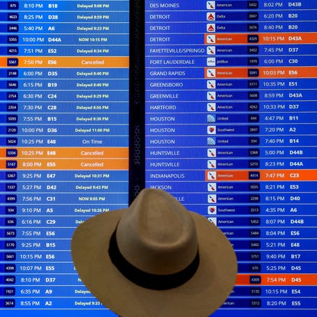 Travelers check their flight status at Ronald Reagan Washington National Airport iin this file photo from June 30, 2023.