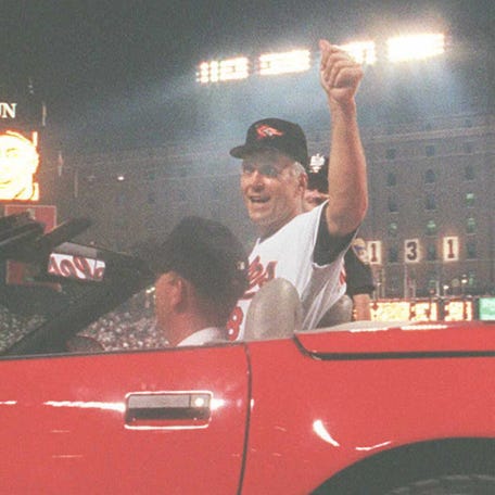 Cal Ripken Jr. of the Baltimore Orioles waves to the crowd as he is driven around the field during a post-game ceremony.