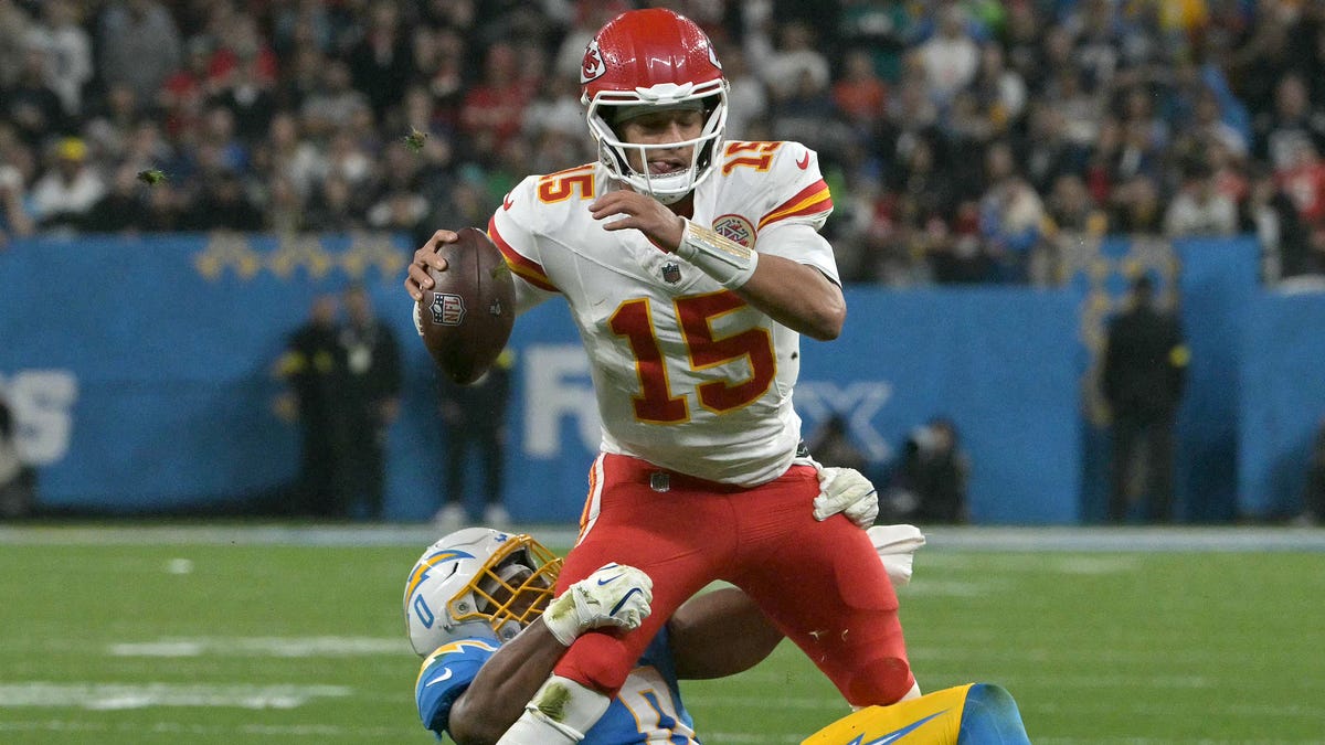 Kansas City Chiefs quarterback #15 Patrick Mahomes is tackled by Los Angeles Chargers linebacker #0 Daiyan Henley.