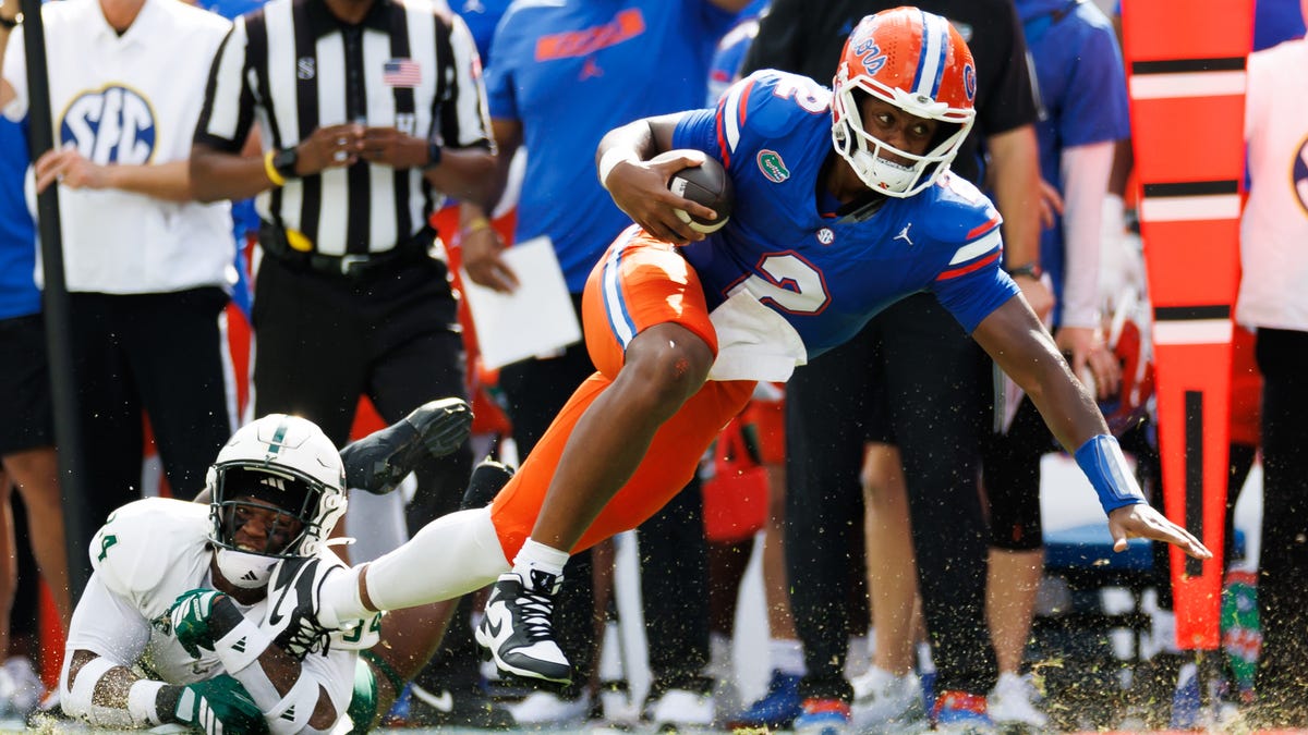 Florida quarterback DJ Lagway (2) runs for a first down against South Florida linebacker Mac Harris (24) during the first half at Ben Hill Griffin Stadium.