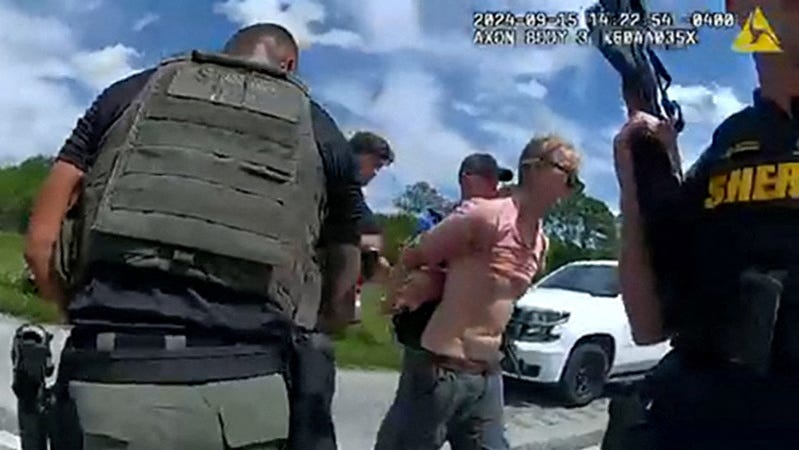 Ryan W. Routh, suspected of attempting to assassinate Republican presidential nominee and former U.S. President Donald Trump at his West Palm Beach golf course, is led by two Martin County Sheriff's Office deputies after his arrest during a traffic stop near Palm City, Florida, U.S., September 15, 2024 in a still image from body camera video. Martin County Sheriff's Office/Handout via REUTERS THIS IMAGE HAS BEEN SUPPLIED BY A THIRD   PARTY