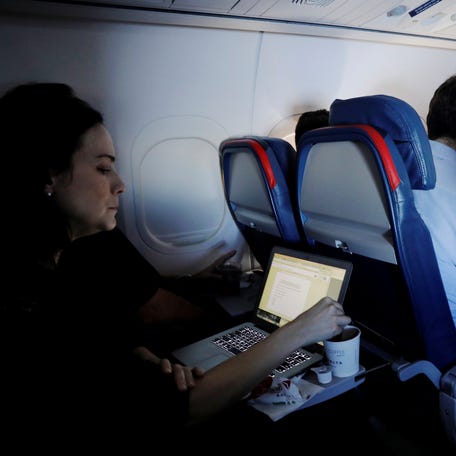 Passengers use their laptops on a flight out of John F. Kennedy (JFK) International Airport in New York, U.S., May 26, 2017. Picture taken May 26, 2017. REUTERS/Lucas Jackson