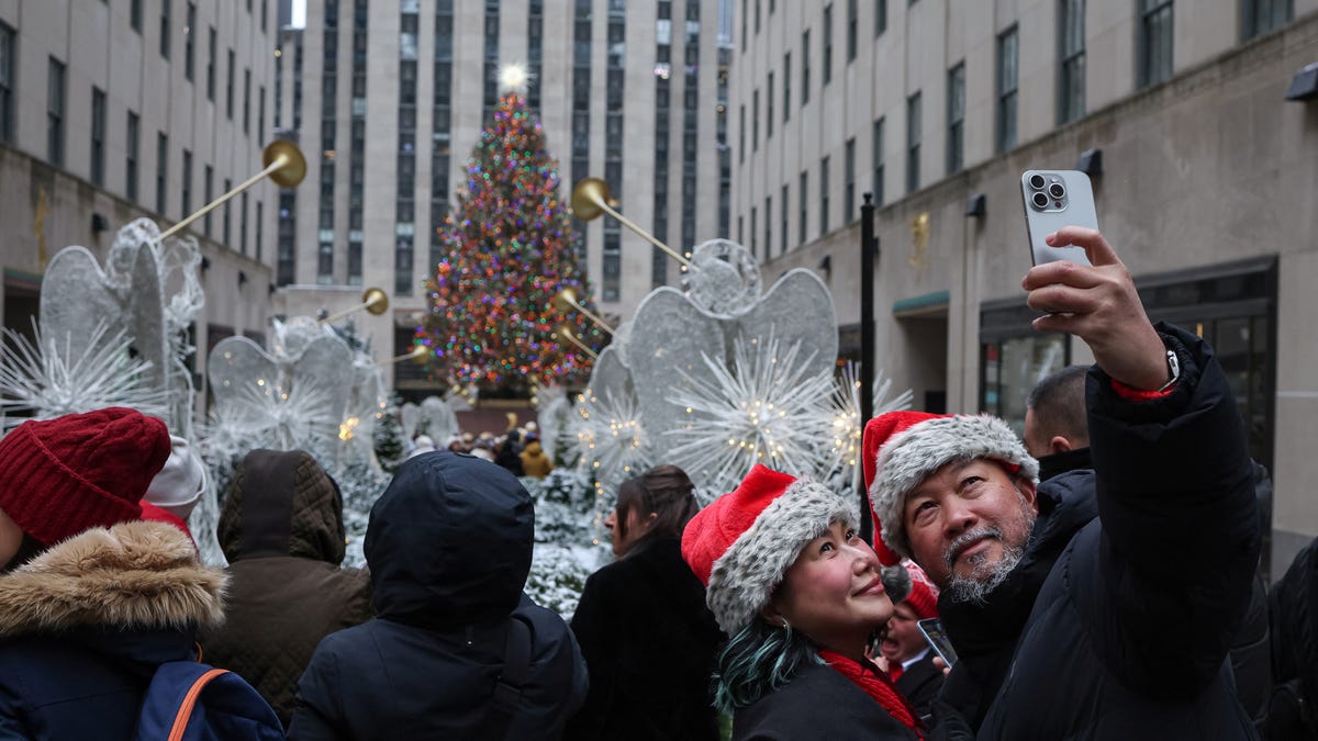 Two people snap a selfie in front of the Rockefeller Center Christmas Tree in Manhattan on Dec. 24, 2024.