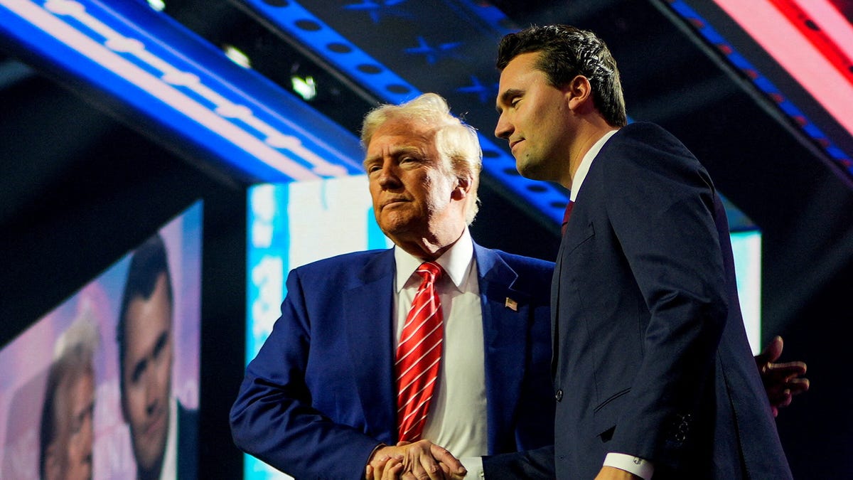 President-elect Donald Trump shakes hands with Turning Point USA founder Charlie Kirk, at Turning Point USA's AmericaFest in Phoenix, Arizona, on Dec. 22, 2024.