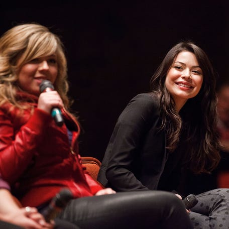 Miranda Cosgrove (R) smiles as Jennette McCurdy addresses the crowd during a question and answer session at Naval Submarine Base New London on Jan. 11, 2012 in Groton, Connecticut.