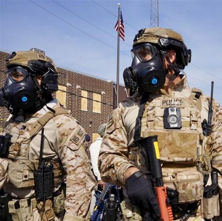 Federal agents stand outside a U.S. Customs and Immigration Enforcement processing center in Broadview, Illinois. The site has become the focus of Chicago-area protests against immigration enforcement.